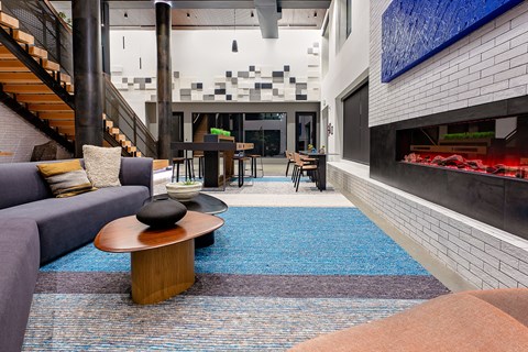 a living room with a fireplace and a blue rug